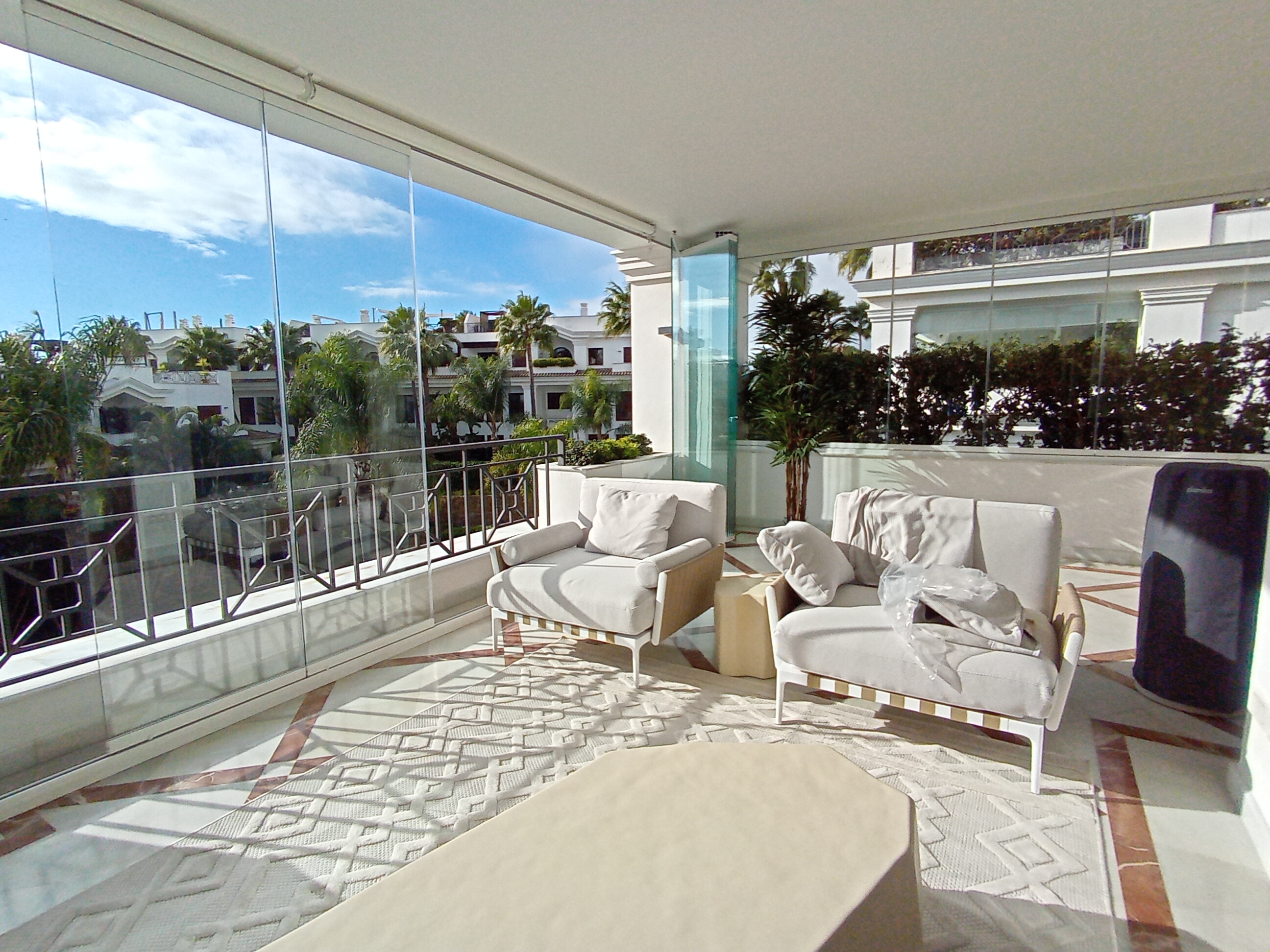 Prywatny taras z przeszkleniem i widokiem na palmy