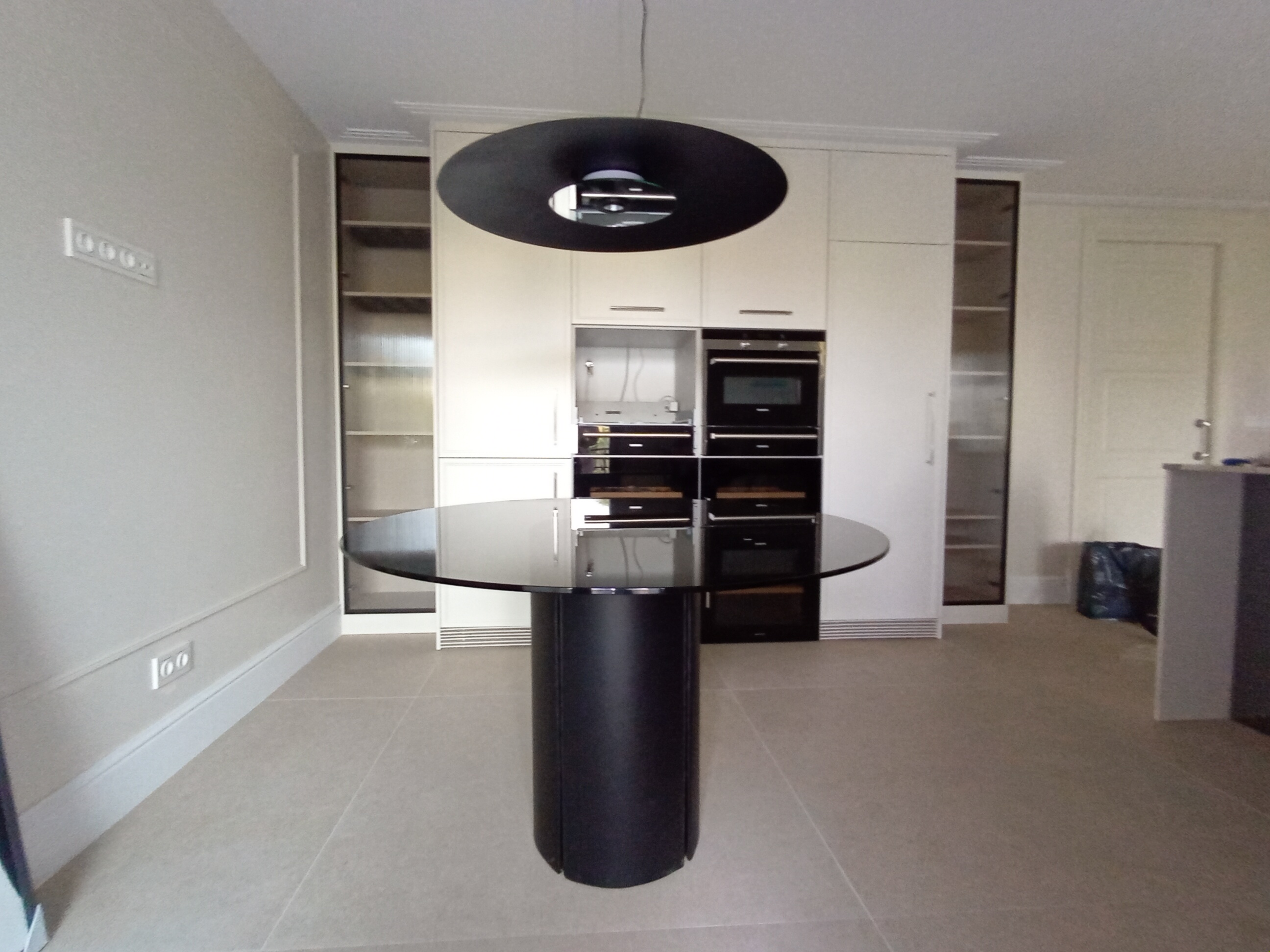 Nowoczesna kuchnia z czarną wyspą i okrągłym blatem